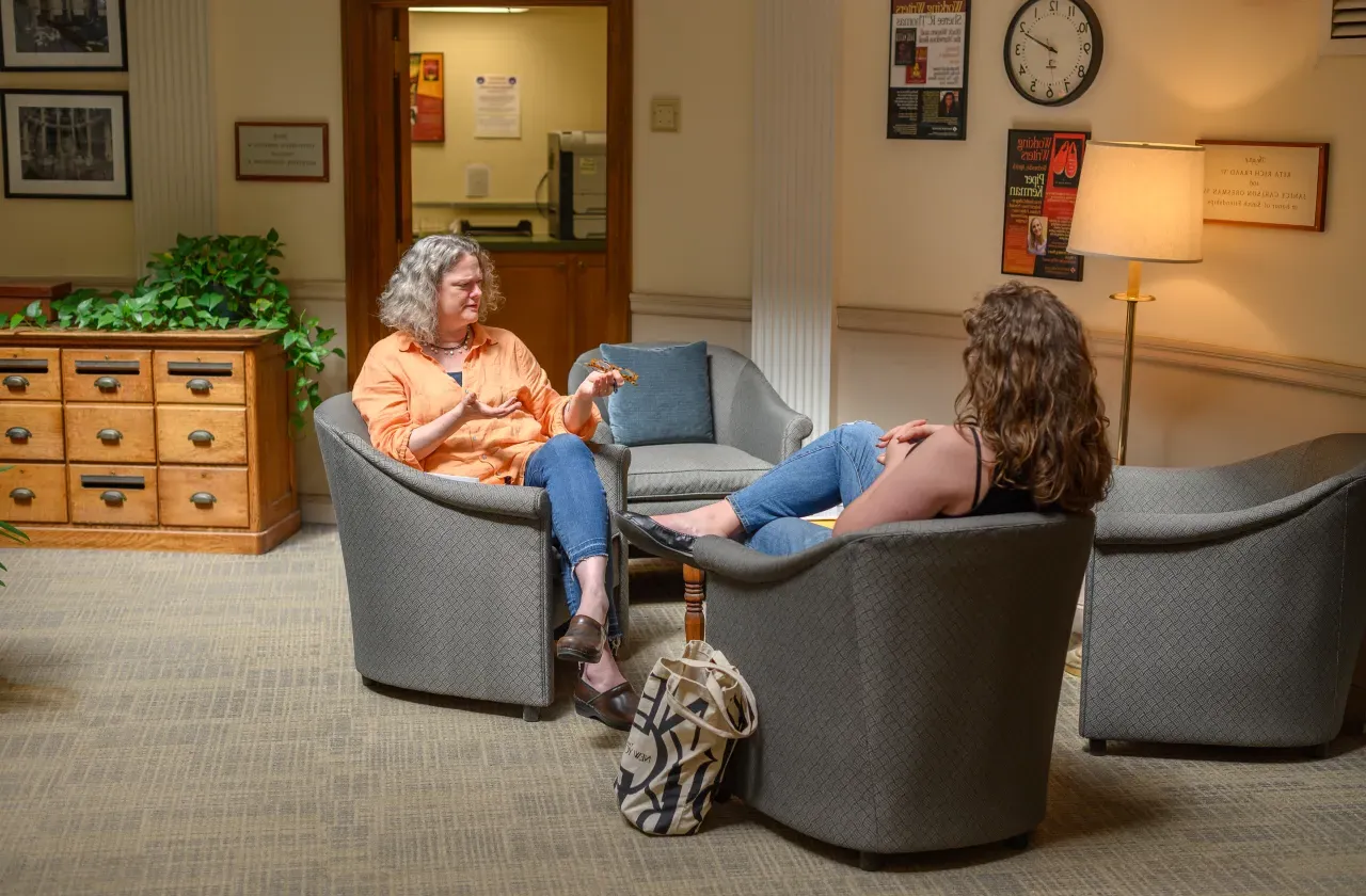 A student and writing instructor talking.